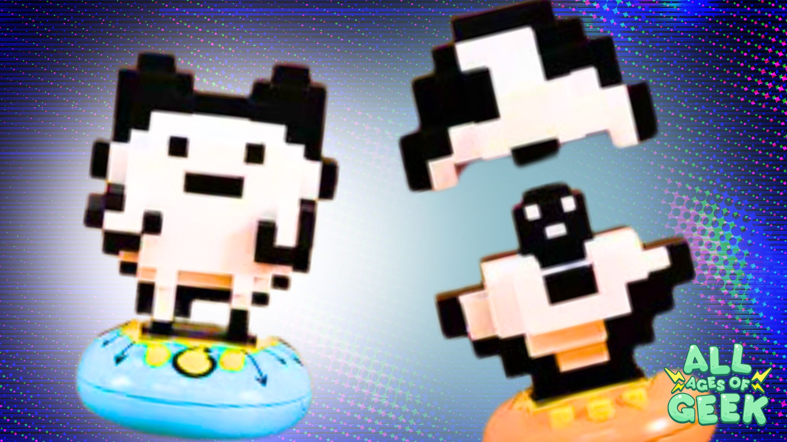 Pixelated Tamagotchi figures from the PoppeDot Collection vol.1 on colorful pedestals, featuring two characters: one with black ears and a blue pedestal, and the other with an open shell revealing a smaller black and white character inside on an orange pedestal. The All Ages of Geek logo is visible in the bottom right corner.