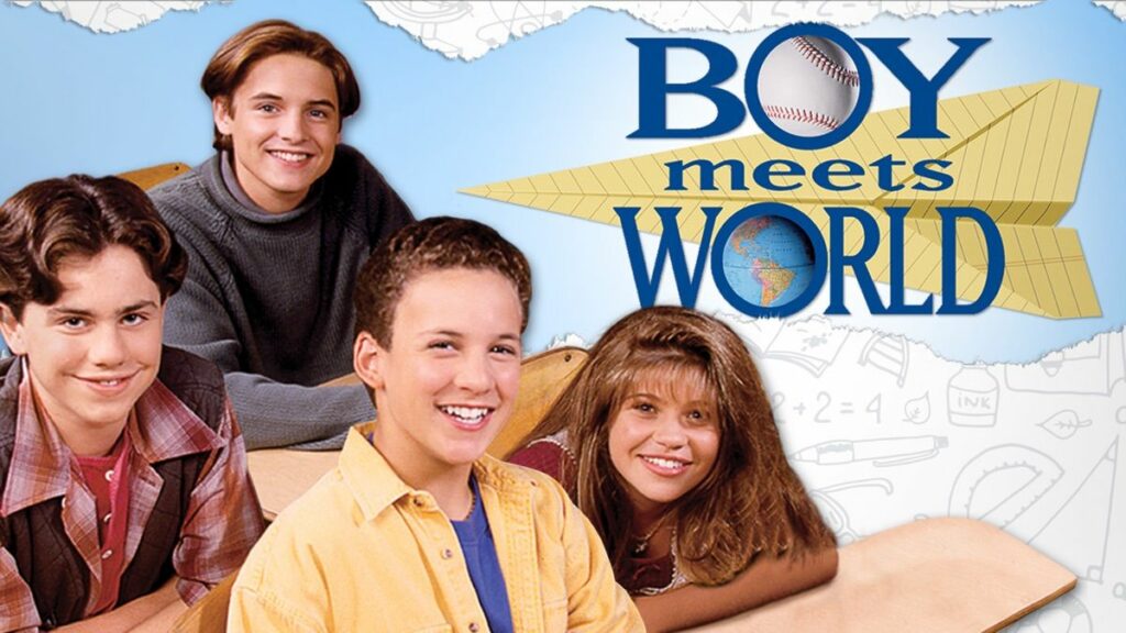 In the image, the main cast of the 90s sitcom "Boy Meets World" is shown, capturing the youthful and adventurous spirit of the show. From left to right, the characters are seated at school desks with the show's title prominently displayed above them. We see Shawn Hunter, with his signature floppy hair and a mischievous smile, Cory Matthews, front and center, with a cheerful and bright expression, and Topanga Lawrence, with her long hair and a friendly smile. In the background, Eric Matthews stands, looking cool and relaxed. The backdrop features a light blue sky with clouds and sketches of school-related items, emphasizing the show's focus on growing up and learning life lessons. The title "Boy Meets World" is prominently displayed, with a paper airplane and a globe incorporated into the design, highlighting the theme of exploring the world and the experiences that come with it.