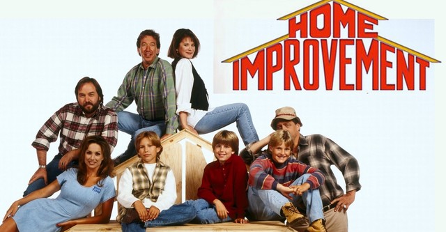 In the image, the main cast of the 90s sitcom "Home Improvement" is shown together, capturing the essence of the show's family and DIY themes. They are posed around a wooden structure, symbolizing the show's focus on home renovation and construction. From left to right, the characters are Patricia Richardson as Jill Taylor, sitting on the floor in a blue dress, looking relaxed and friendly; Richard Karn as Al Borland, standing and dressed in a plaid shirt and jeans, giving a warm smile; Tim Allen as Tim "The Tool Man" Taylor, standing on the wooden structure in his signature plaid shirt, looking enthusiastic and confident; Debbe Dunning as Heidi, perched on the wooden structure in jeans and a white top, striking a casual pose; the three Taylor children, Brad (Zachery Ty Bryan), Randy (Jonathan Taylor Thomas), and Mark (Taran Noah Smith), seated in front, with Brad and Randy leaning against the structure and Mark sitting in the middle, all looking cheerful and playful; and Earl Hindman as Wilson, partially hidden behind the structure, true to his character's trademark of being seen only partially. The title "Home Improvement" is displayed prominently at the top in bold, red letters, with a house-shaped outline around it. The image encapsulates the family-friendly, humorous, and hands-on spirit of the show.