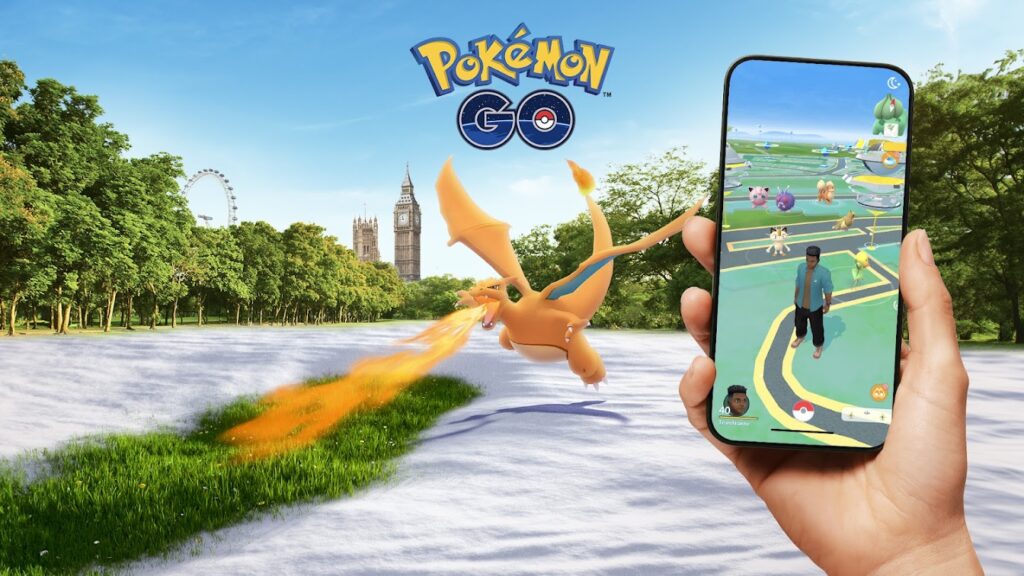 Promotional image for the mobile game Pokémon GO featuring a person holding a smartphone displaying the game interface. The game screen shows a player character surrounded by various Pokémon, including Jigglypuff, Venonat, and Meowth. In the augmented reality (AR) scene outside the phone, a Charizard is flying in a park, breathing fire. The background includes a view of the London Eye and Big Ben, placing the scene in a recognizable London park. Used for New Jersey Video Game Ideas Article.