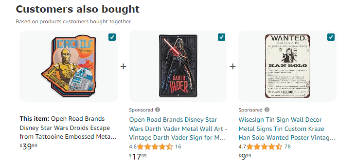 The image shows a "Customers also bought" section from Amazon, featuring three Star Wars-themed metal signs that customers frequently purchase together:

On the left, the main item is the "Open Road Brands Disney Star Wars Droids Escape from Tatooine Embossed Metal Sign," priced at $39.99. The sign features C-3PO and R2-D2 with the word "Droids" at the top.

In the center, there is a "Open Road Brands Disney Star Wars Darth Vader Metal Wall Art," which is a vintage-style sign depicting Darth Vader with his lightsaber, priced at $17.99.

On the right, a "Wisesign Tin Sign Wall Decor" features a "Wanted" poster for Han Solo, priced at $9.99. The sign has a vintage look, resembling an old-fashioned wanted poster with details about Han Solo.

All three products have customer ratings and are highlighted as items that are commonly bought together, suggesting a thematic connection for fans of Star Wars wall decor.