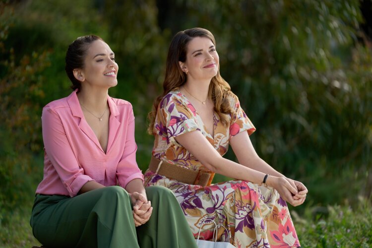  Two women sitting outdoors, smiling and enjoying the view. From Hallmark's "For Love & Honey"
