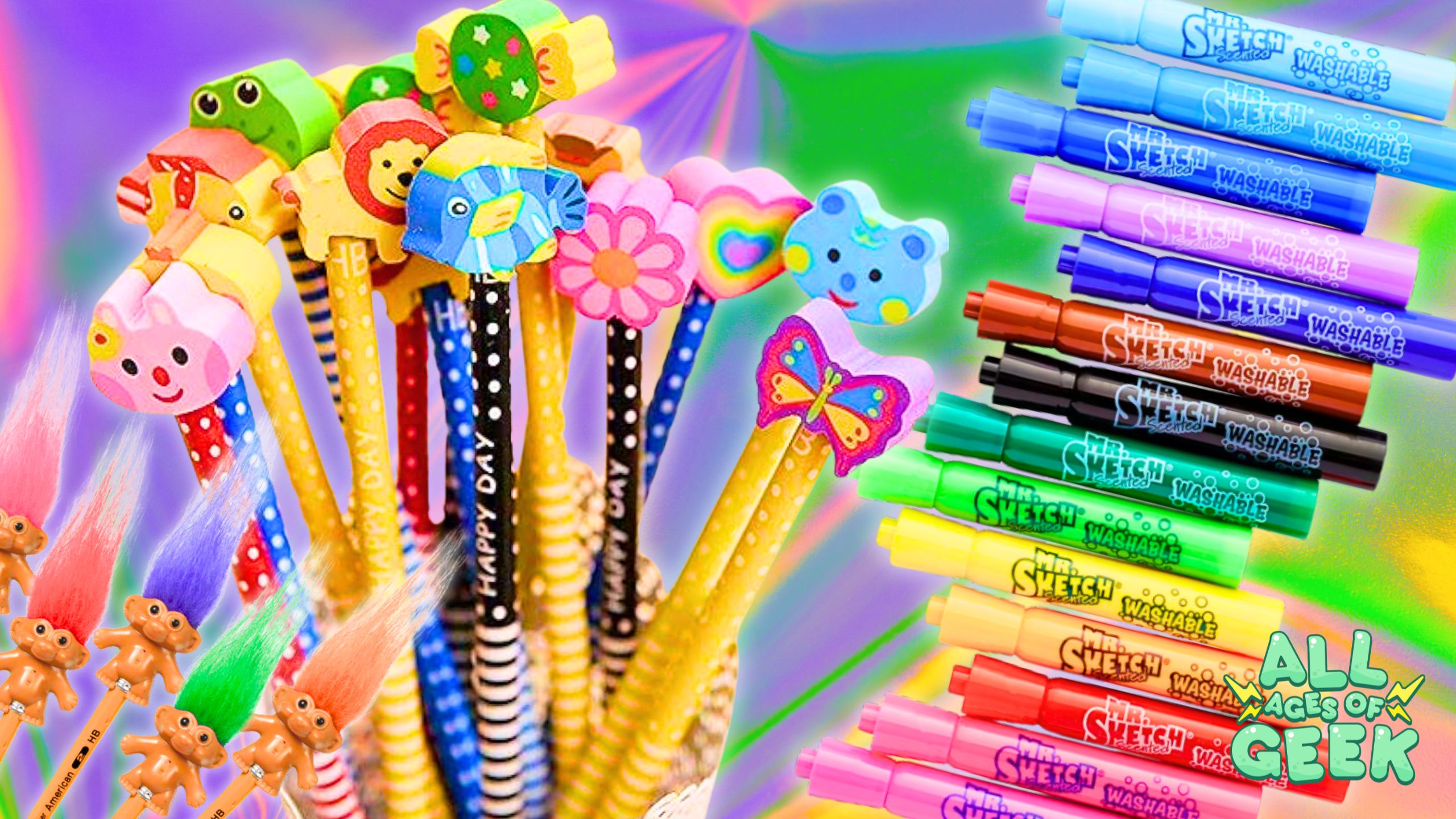 **Image Description:** The image showcases a colorful array of nostalgic 90s school supplies. On the left, there are pencils with various fun and whimsical pencil top erasers, including animals, flowers, and hearts. Below them are Troll Pencil Toppers with vibrant, fluffy hair. On the right, there is a rainbow-like display of Mr. Sketch Scented Washable Markers in various colors. The "All Ages of Geek" logo is positioned in the bottom right corner. The background features a gradient of bright, cheerful colors, enhancing the playful and nostalgic theme.