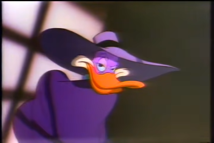 Darkwing Duck looking suave in his purple hat and cape shadows draped over his face.