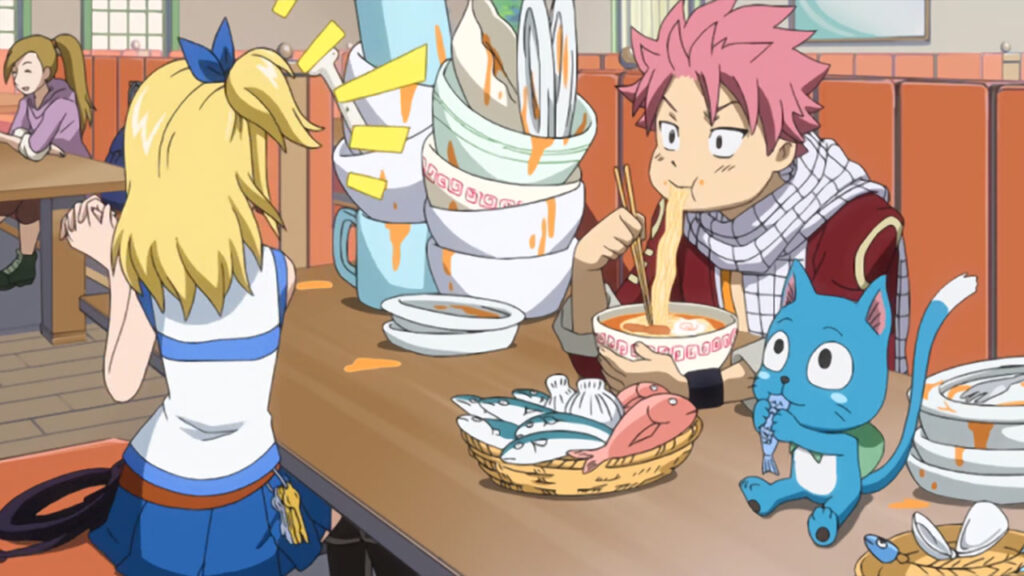 Natsu slurping down ramen with several bowls stacked up on his side. The table is sprawled with a mess with baskets of fish ready to be consumed by Happy. Lucy is shocked and pushes away while people happily chatter in the background.