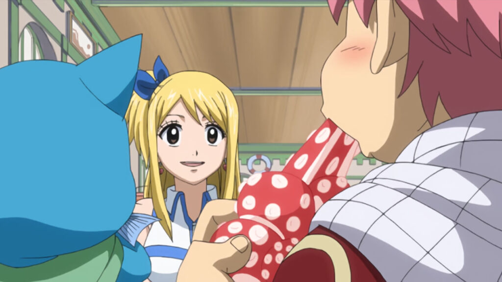 Lucy, Happy and Natsu sitting in a restaurant. Natsu is chomping and eating what looks to be octopus with blushing cheeks, while Lucy stares at him and Happy munches happily on a gray fish.