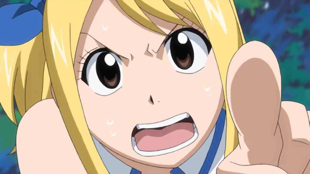 Lucy pointing directly at the camera as sweat drips from her cheeks and she stares back with an angry expression.