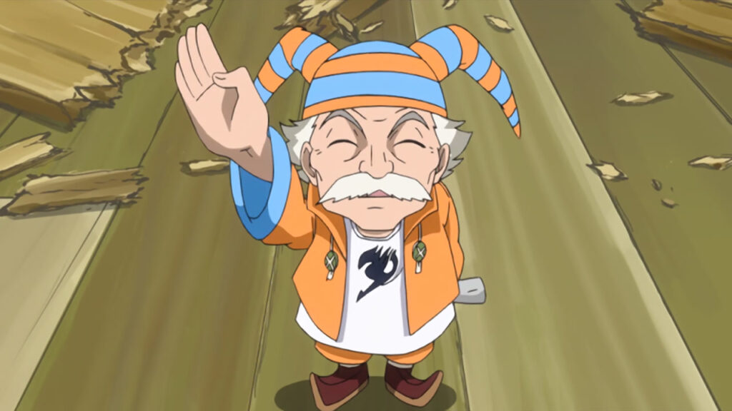 Master Makarov waves and looks up at Lucy with an adorable expression wearing his orange suit and jester orange and blue hat.