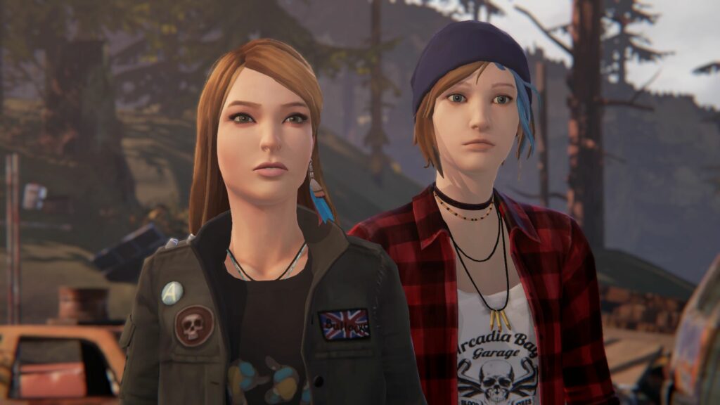 Chloe and Rachel stare ahead at a person in conversation, Rachel dressed in a pin and patch covered leather jacket, Chloe dressed in flannel.