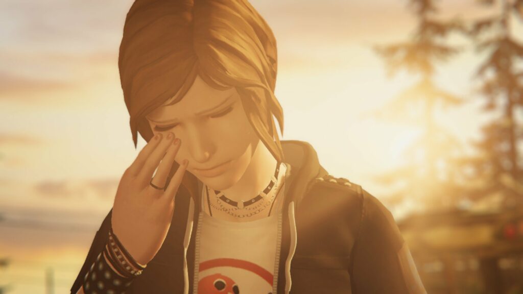 Chloe Price cries in the foreground, her head tilted downward with golden hour sunlight basking over her entire body.