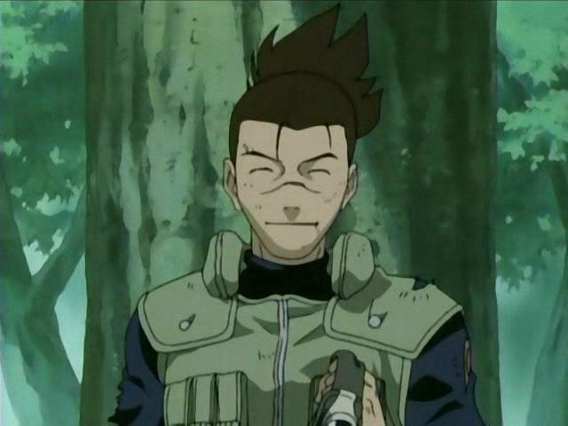 Iruka smiles without his headband, holding it in his hand in a forest.