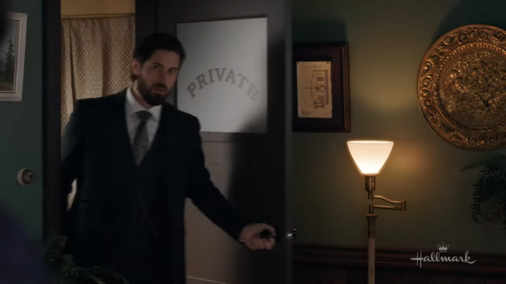 Lucas Bouchard entering a room marked 'PRIVATE': Lucas Bouchard, in a dark suit, opens a door marked 'PRIVATE' with a worried expression.