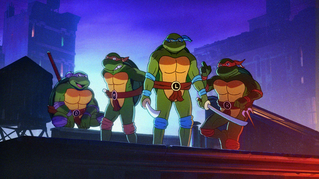 An animated scene featuring the Teenage Mutant Ninja Turtles standing together on a rooftop at night with a city skyline in the background. From left to right, Donatello (wearing a purple mask and holding a bo staff), Michelangelo (wearing an orange mask and holding nunchaku), Leonardo (wearing a blue mask and holding katanas), and Raphael (wearing a red mask and holding sai) are all in action-ready poses. The scene is lit with a moody, bluish hue, adding to the nighttime atmosphere.