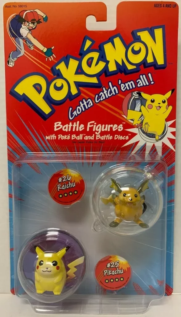 Image of a vintage Pokémon Battle Figures toy package from the 1990s. The packaging features the classic red design with the Pokémon logo and the slogan 'Gotta catch 'em all!' at the top. The figures included are #25 Pikachu and #26 Raichu, each displayed in clear plastic bubbles. The package also includes two Battle Discs, one for each figure, with the names 'Pikachu' and 'Raichu' printed on them. The top left corner of the packaging features an illustration of Ash Ketchum in a dynamic pose, adding to the nostalgic appeal of the toy.