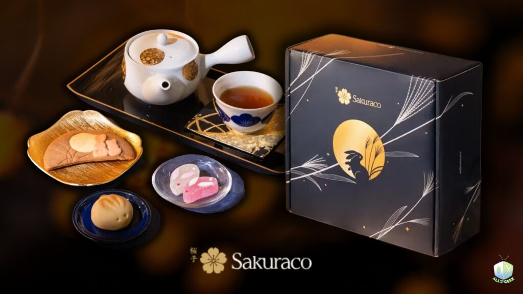 Sakuraco Autumn Moon Festival Box displayed with a Japanese teapot, tea cup, and seasonal sweets including a rabbit cookie, rabbit-shaped jelly candies, and a rabbit manju, set against a warm festive background.