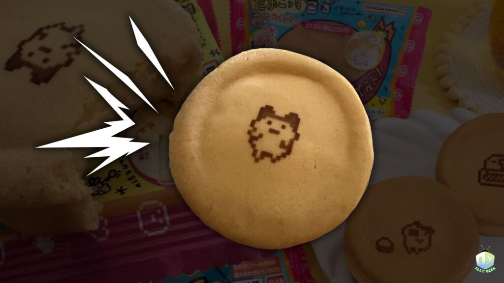 Tamagotchi Manmaruyaki pancake with an adorable pixel Tamagotchi character printed on top, displayed with other packaged treats from Bandai Namco for All Ages of Geek’s review.