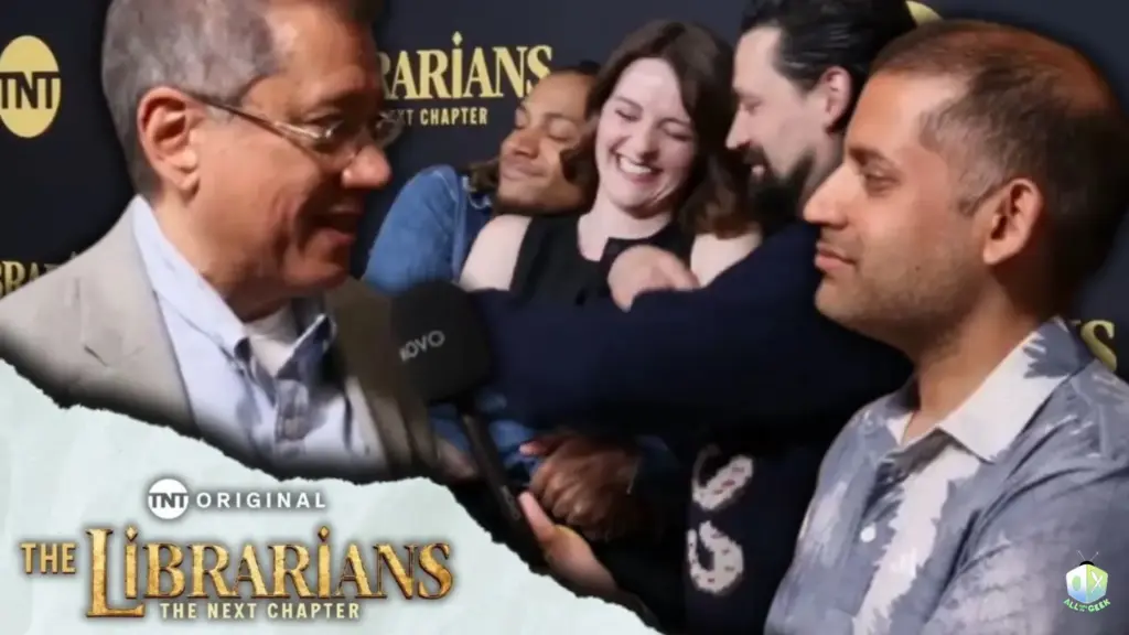 Cast members from The Librarians: The Next Chapter share a playful moment behind Dean Devlin during a red carpet interview with All Ages of Geek.